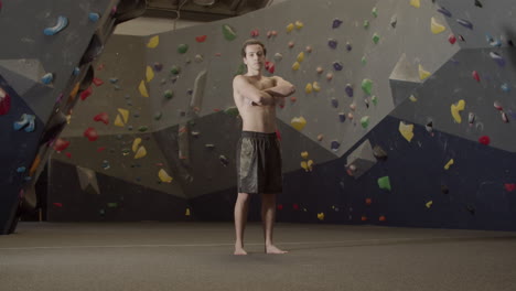 Portrait-Shot-Of-A-Young-Shirtless-Sportsman-Standing-In-Bouldering-Gym-And-Looking-At-The-Camera