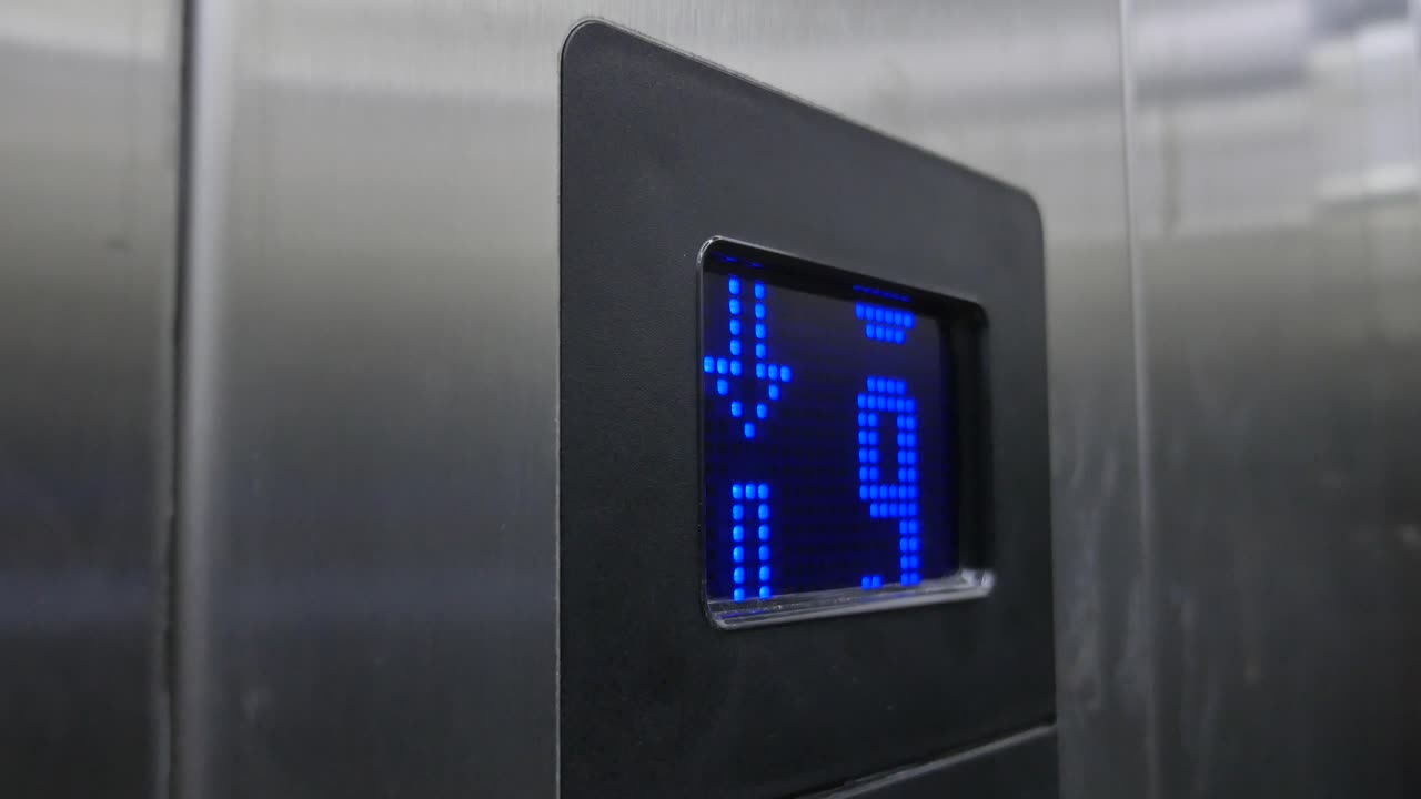 disparo en primer plano de un panel de botones de ascensor con un número 4 encendido en la pantalla