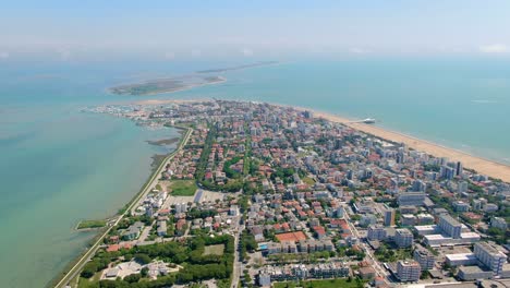 Luftaufnahme-Der-Stadt-Lignano-Sabbiadoro-Zwischen-Der-Lagune-Von-Marano-Und-Der-Adria,-Italien