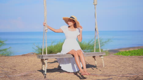 carefree asian woman on big swing, seascape sunny background slomo