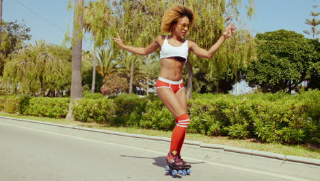 sexy chica afro americana en pantalones cortos en patines