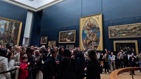 visitors gather around a famous painting