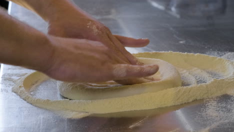 close up of hands preparing fresh pizza dough