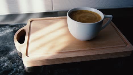 coffee with foam in white cup on wooden table