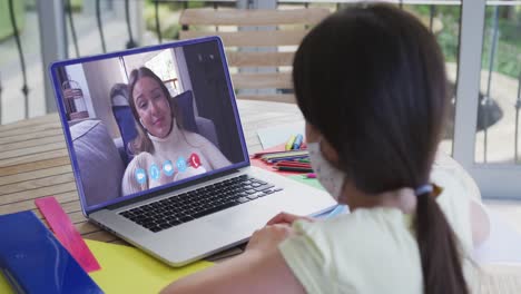 Caucasian-girl-on-laptop-video-chat-wearing-face-mask-at-home