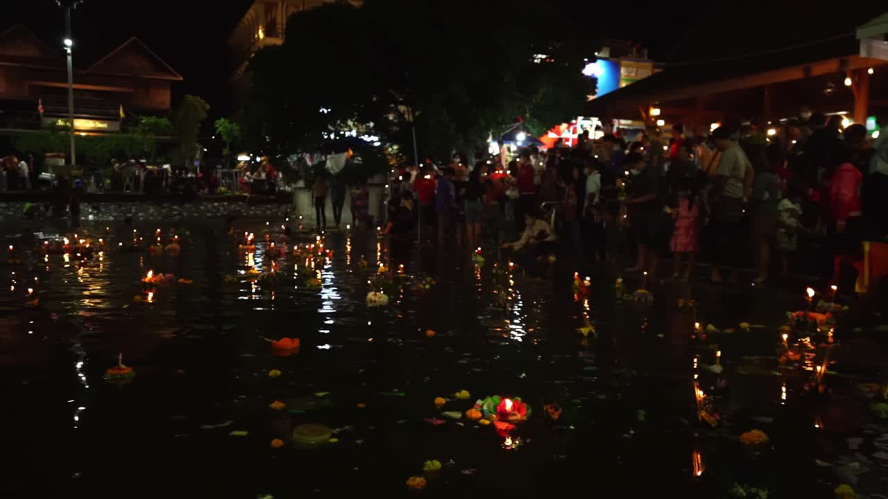 Slow motion People pray and put Loi Krathongs on the water during traditional Thai holiday Loy Krathong in Bangkok, Thailand. Crowd Celebrates. River full of beautiful Krathongs. 4k