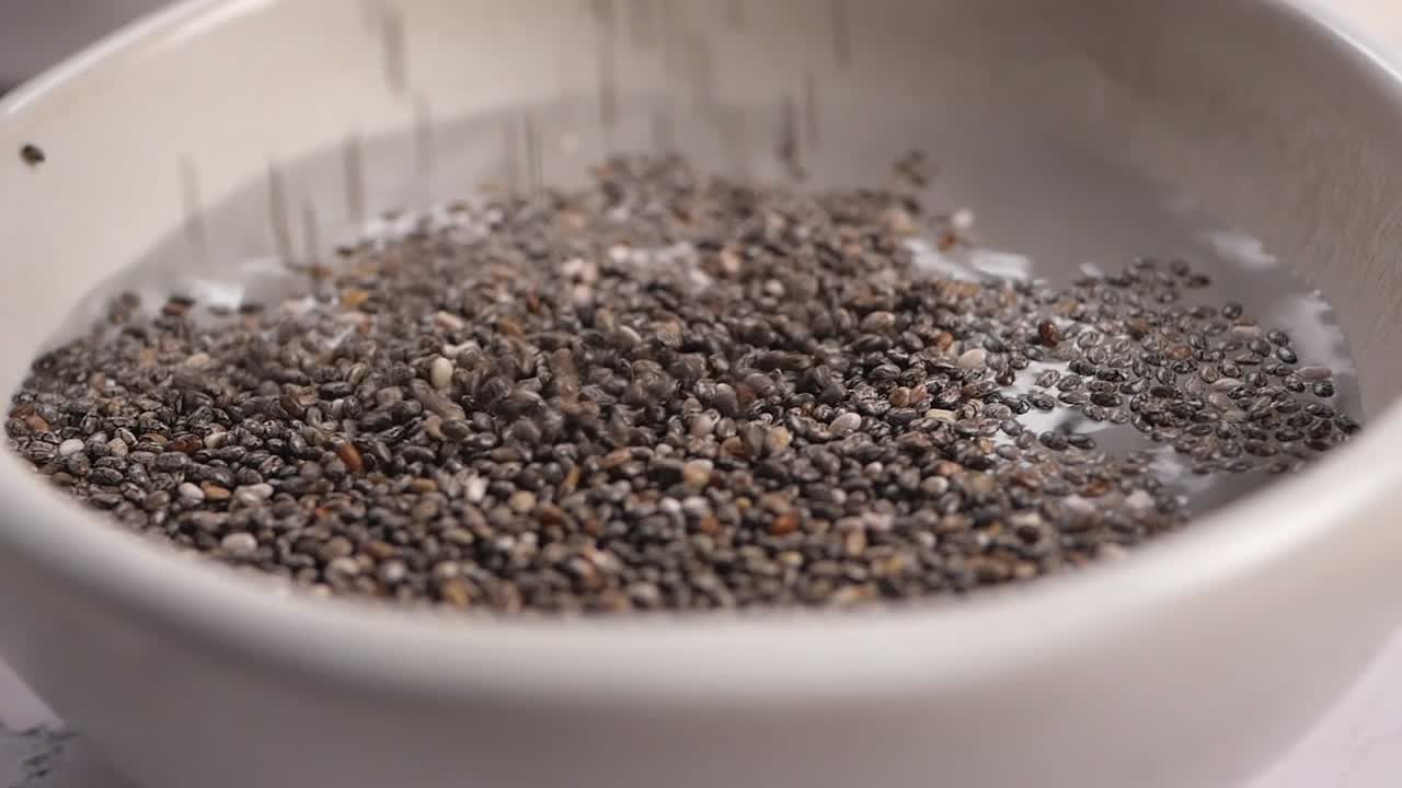 Semi di chia in ammollo nell'acqua in una ciotola bianca