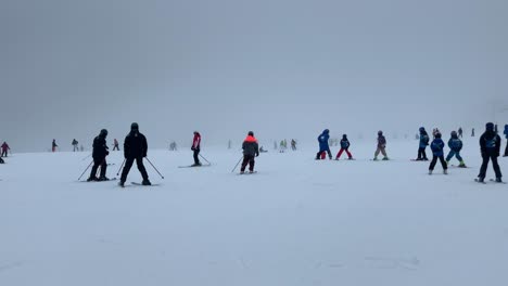 skiing people under very foggy conditions