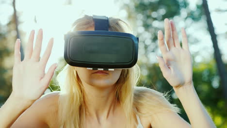 young woman in a helmet of virtual reality touching invisible wall