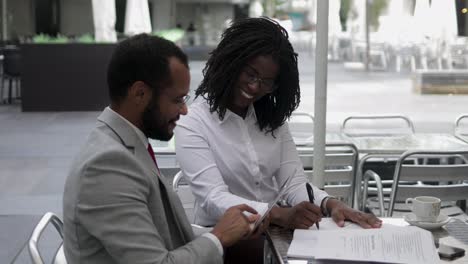 cheerful smiling business people talking at outdoor cafe