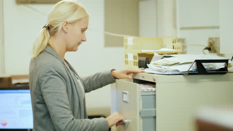 Frau-Entfernt-Dokument-Aus-Aktenschrank