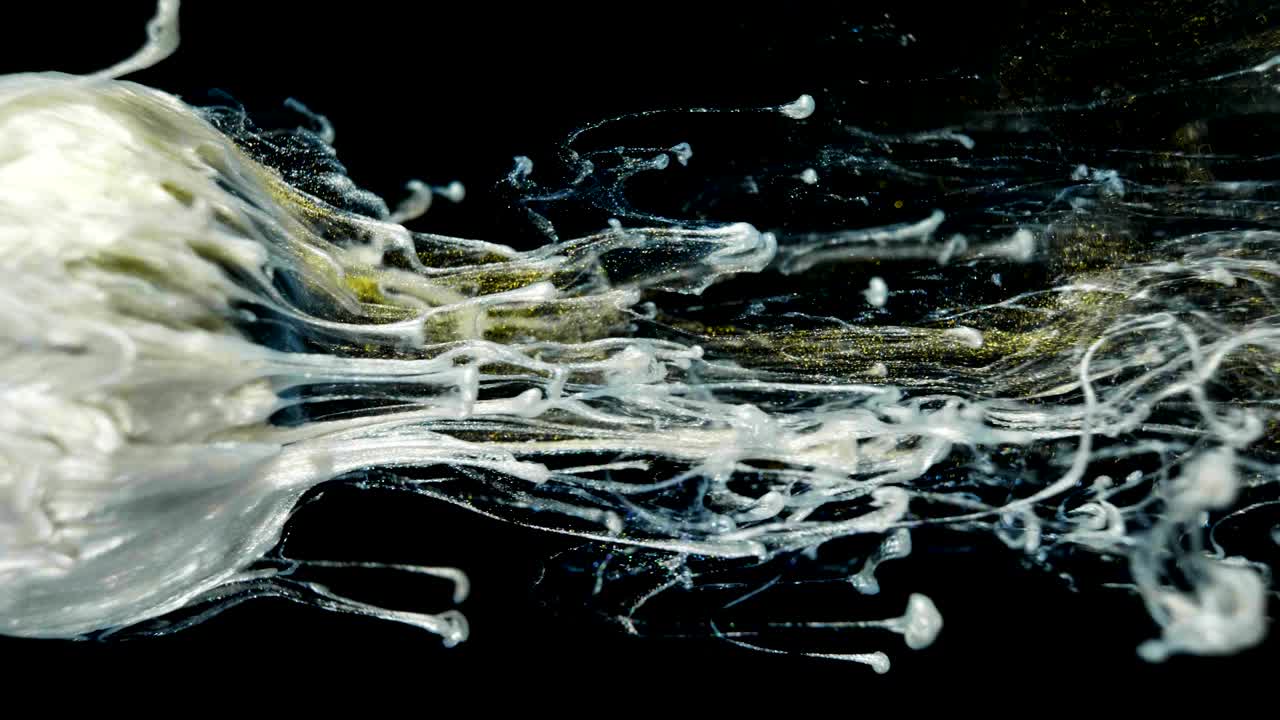 황금빛 빛나는 페인트가 천천히 공에서 흘러나옵니다.