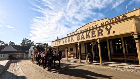 carriage moves past bakery in historical setting