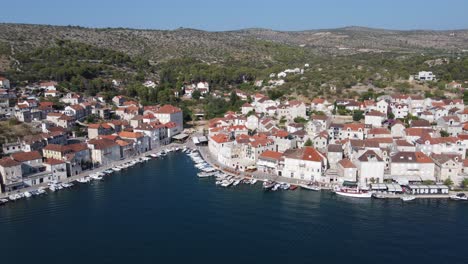 sheltered port marina of milna town brac island, white limestone houses along quays, croatia