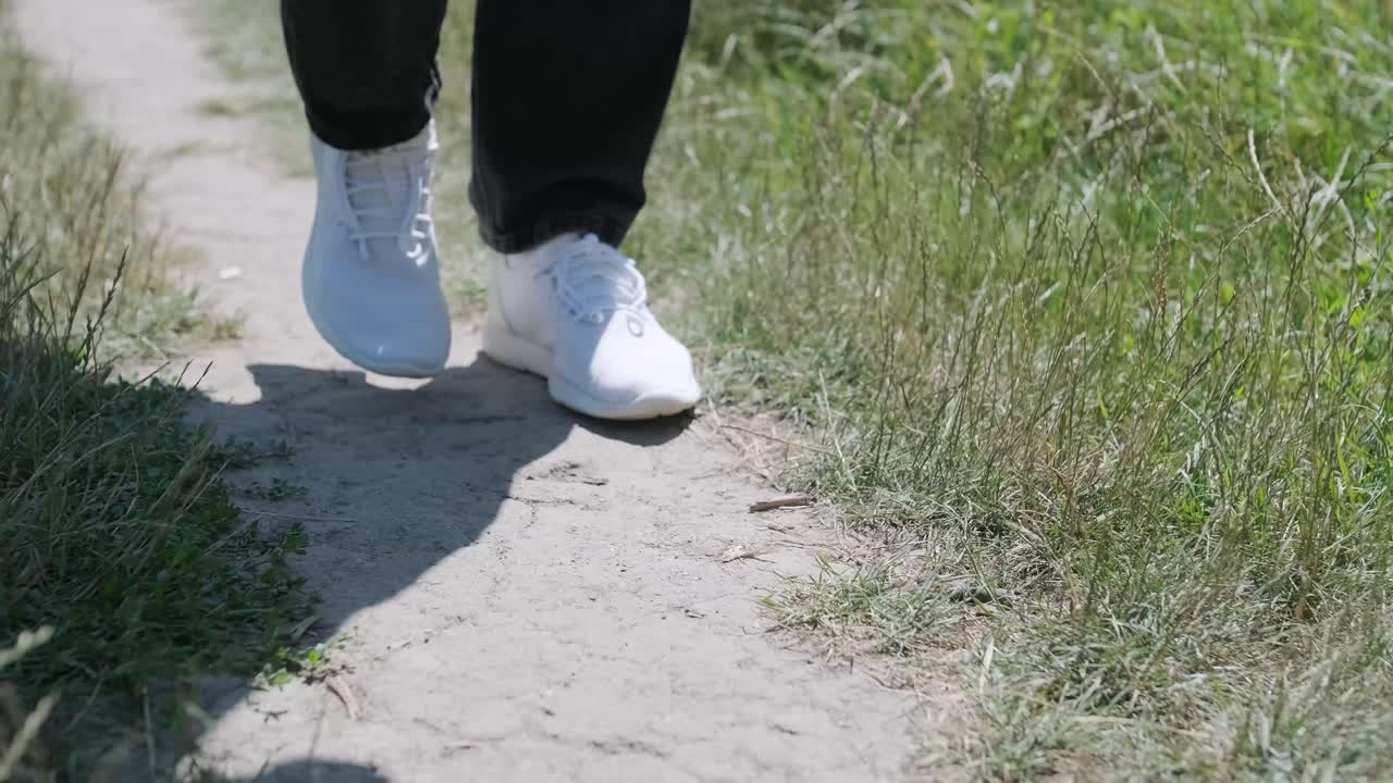 joven caminando con la guitarra en la calle cerca del bosque