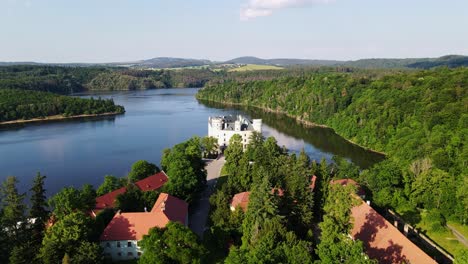 serene aerial shot of orlík castle between lake and countryside at sunset glow
