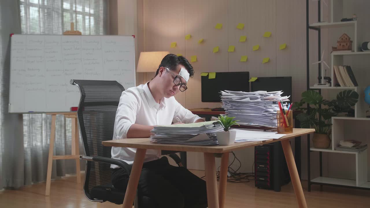 hombre asiático enfermo trabajando duro con documentos en la oficina