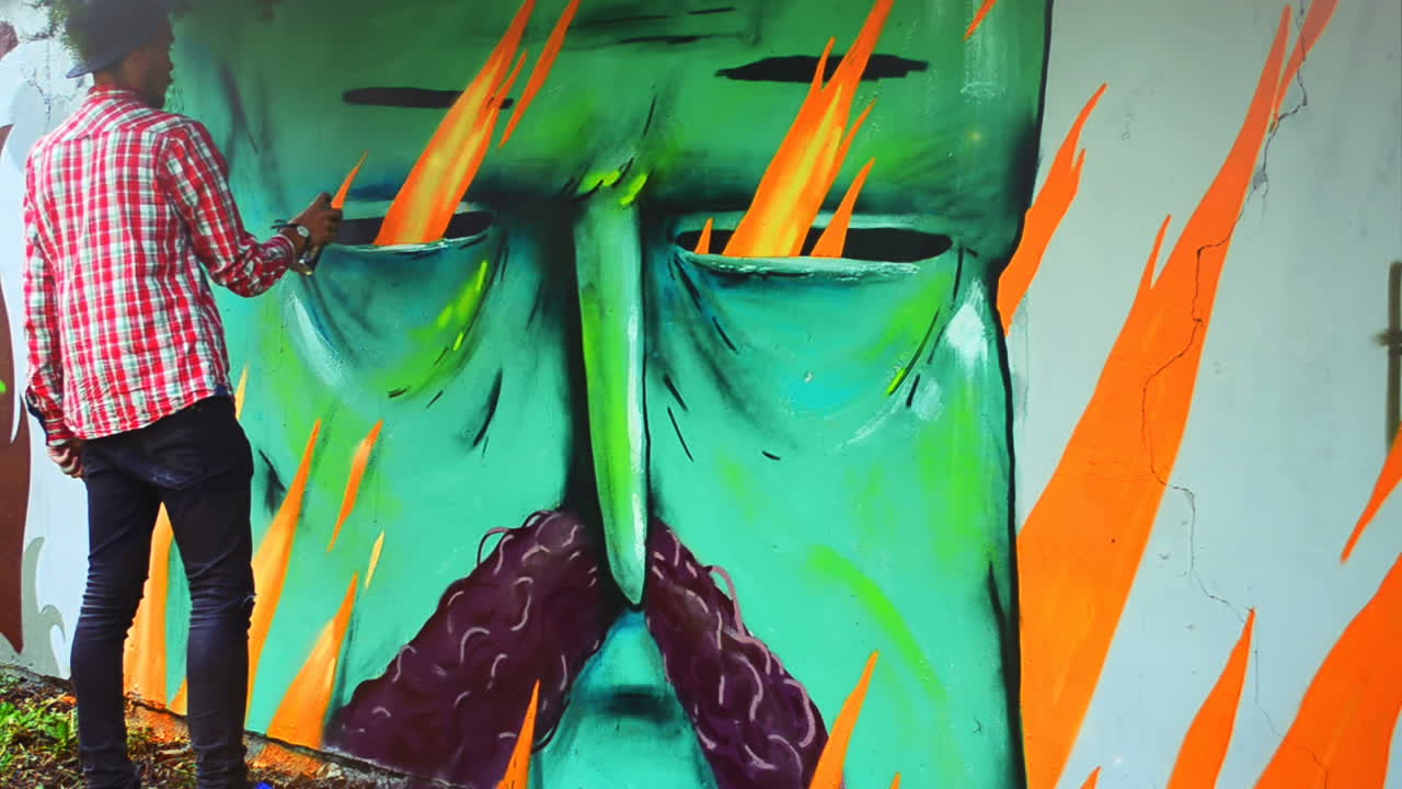 L'artista realizza graffiti su una recinzione. Disegno astratto