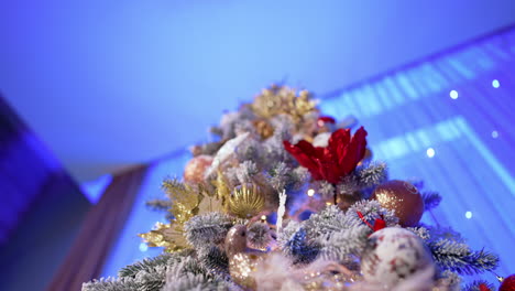 beautiful decoration of the christmas tree. low angle view at the colorful ornaments on the snowy tree. close up.