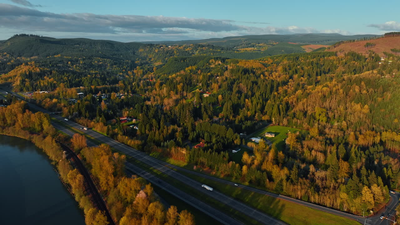 Sunset in the countryside of Oregon State. Beautiful forests covering the mountainous landscape with some village cottages among them. Aerial view.
