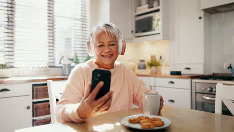 Headphones,-phone-and-senior-woman-in-the-kitchen