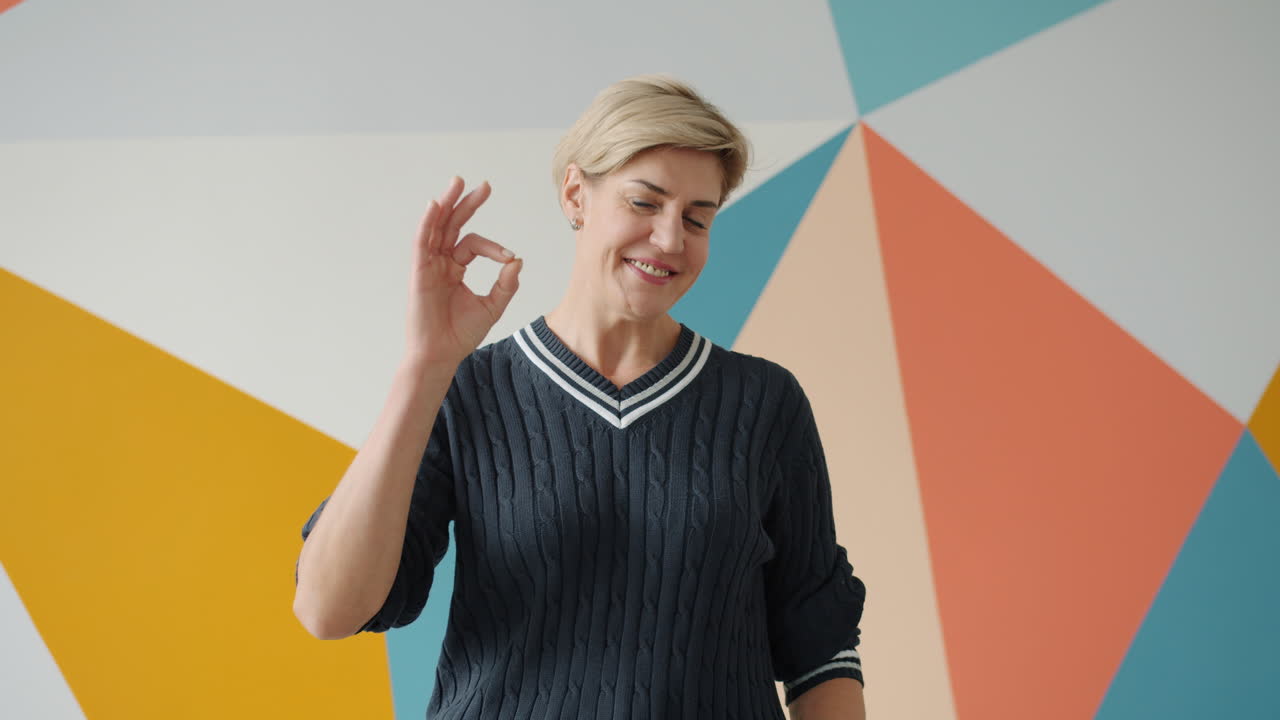 una mujer sonriente dando la señal de "ok"