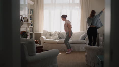 happy teenage girls dancing at home best friends having fun enjoying funky dance moves celebrating vacation weekend at home wearing pajamas