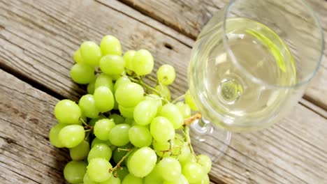 uvas y vino blanco en una tabla de madera