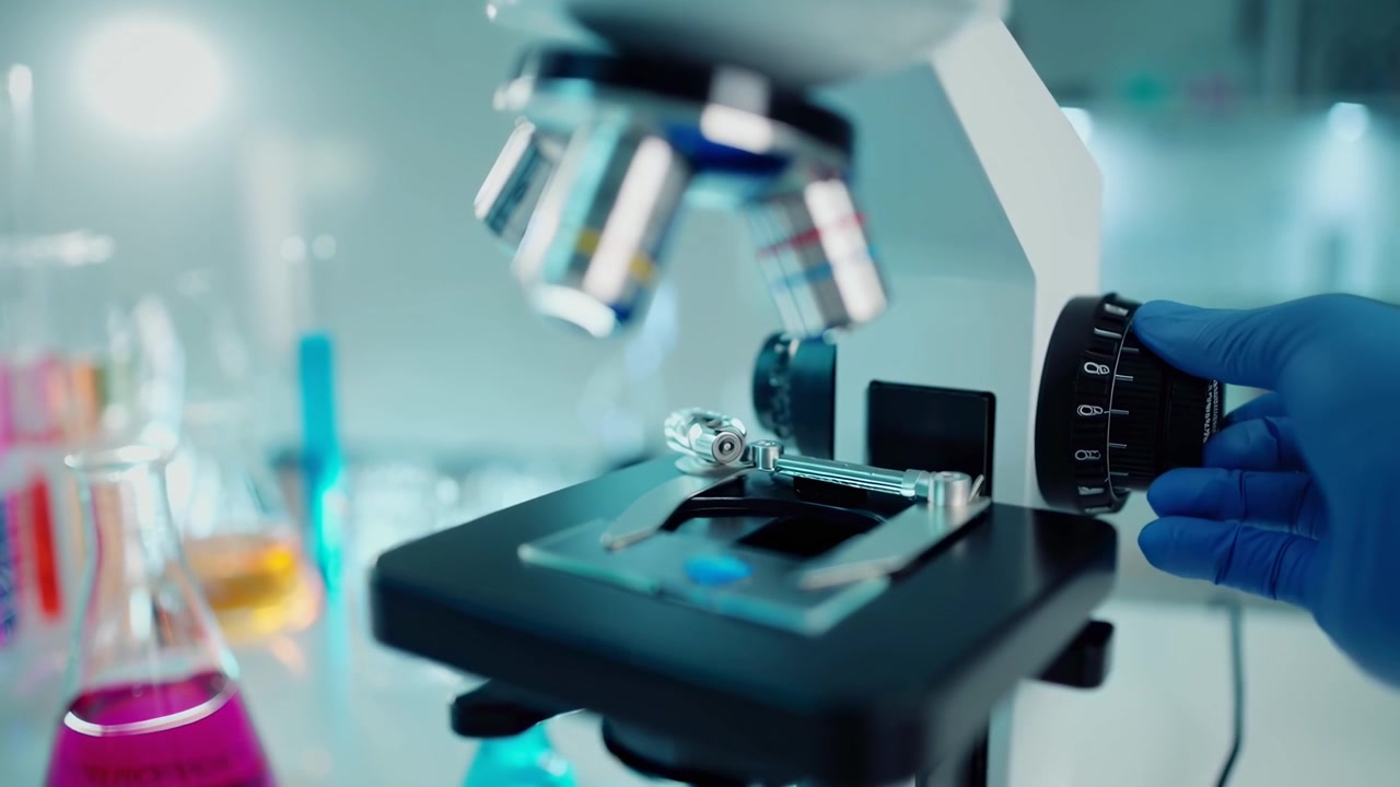 Scientist Adjusting Microscope Focus in Laboratory Setting