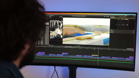 over the shoulder shot of content creator video editor work footage in post production