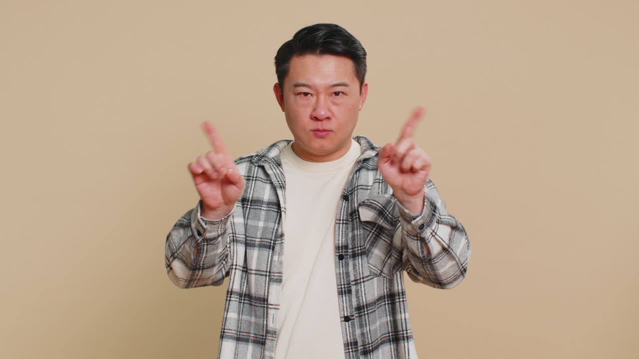 Frightened asian man closing mouth with hands refusing to tell terrible secret unbelievable truth