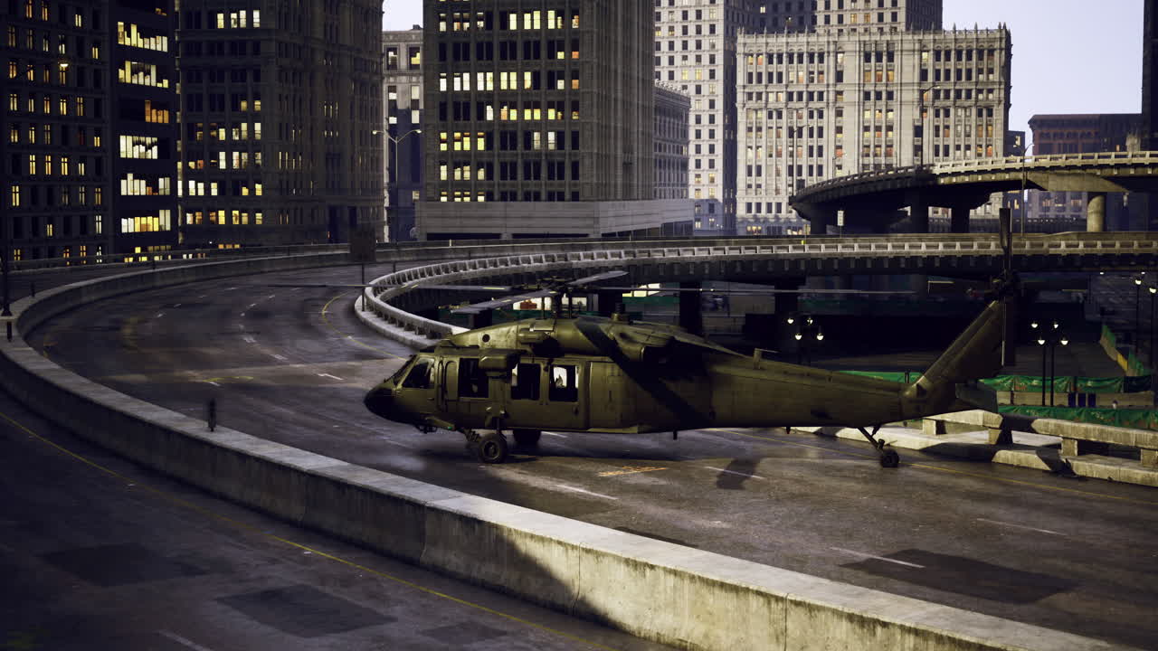 Helicopter parked on a city overpass with buildings in the background at night