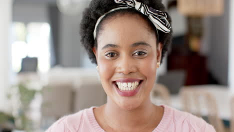 African-American-woman-smiles-warmly-at-home,-her-eyes-sparkling-with-joy