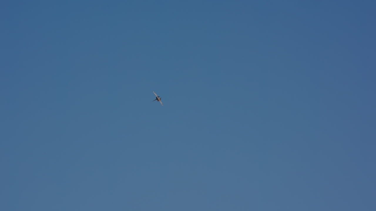Avión de combate realizando maniobras contra un cielo azul