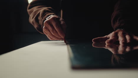 the carpenter putting marks with a pencil on the wooden board before cutting it