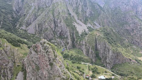 Drohnenaufnahme-Der-Kaukasischen-Berge-Mit-Felsen-Und-Grünen-Bäumen-Im-Tal