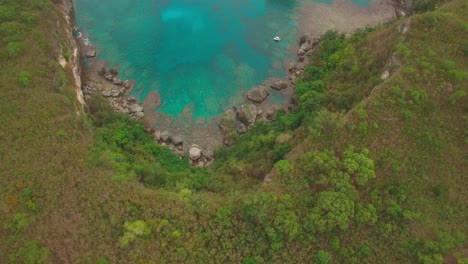 birdseye aerial view of rocky coast of tropical island and aqua blue lagoon