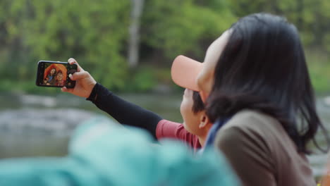 female tourists taking selfie while camping
