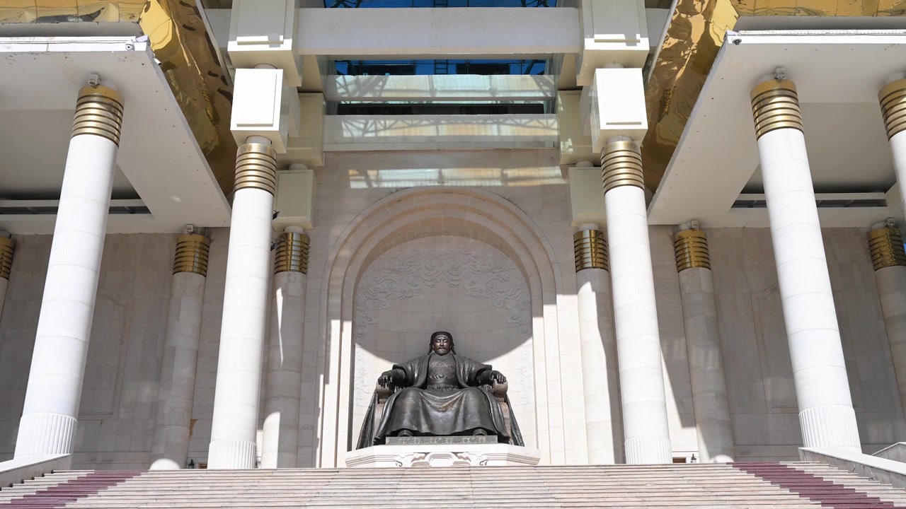 Toma de establecimiento en un día luminoso de la estatua de bronce de Gengis Kan de pie orgullosamente frente al Palacio de Gobierno en la Plaza Sukhbaatar, Ulaanbaatar, Mongolia