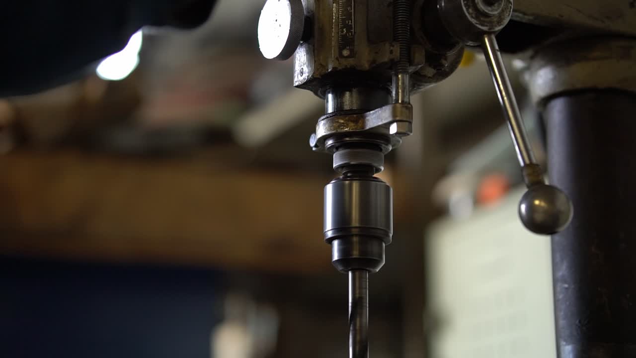 Close-up of a drill press spinning in an industrial workshop