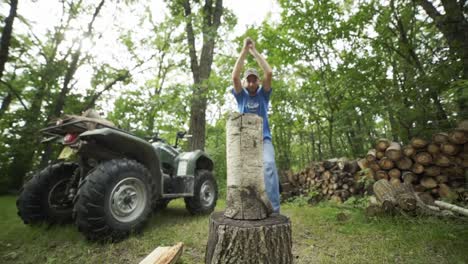 Hombre-Con-Sombrero-Partiendo-Troncos-De-Madera-En-El-Bosque-Frente-A-Atv-A-Cámara-Lenta