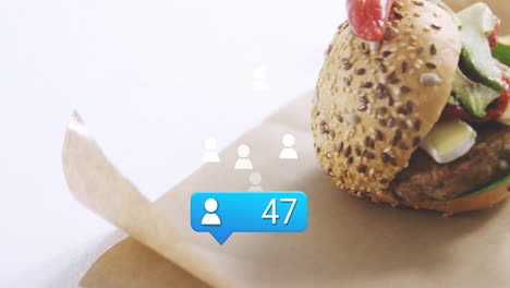 burger with sesame seeds on parchment paper, receiving social media notification