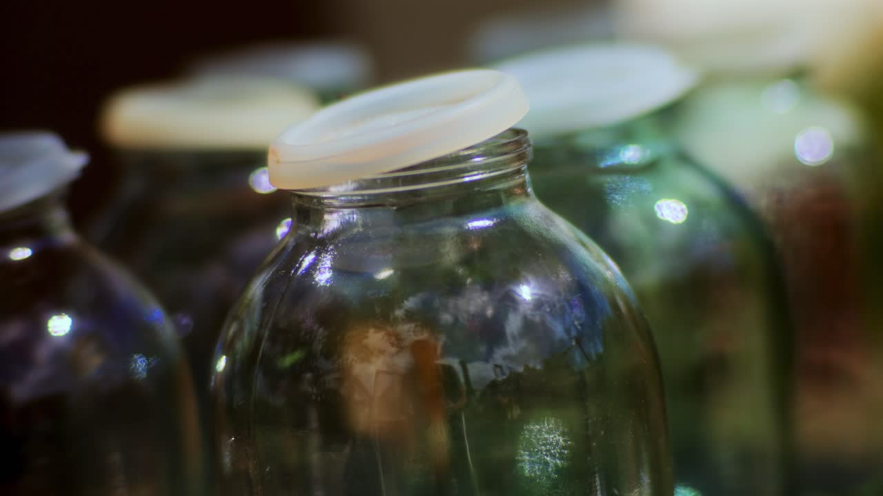 Macro of Empty Glass Bottles with Plastic Lids waiting for Apple Juice