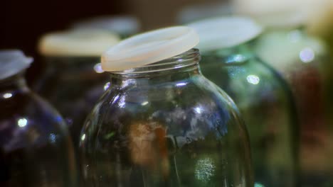 macro de botellas de vidrio vacías con tapas de plástico esperando jugo de manzana