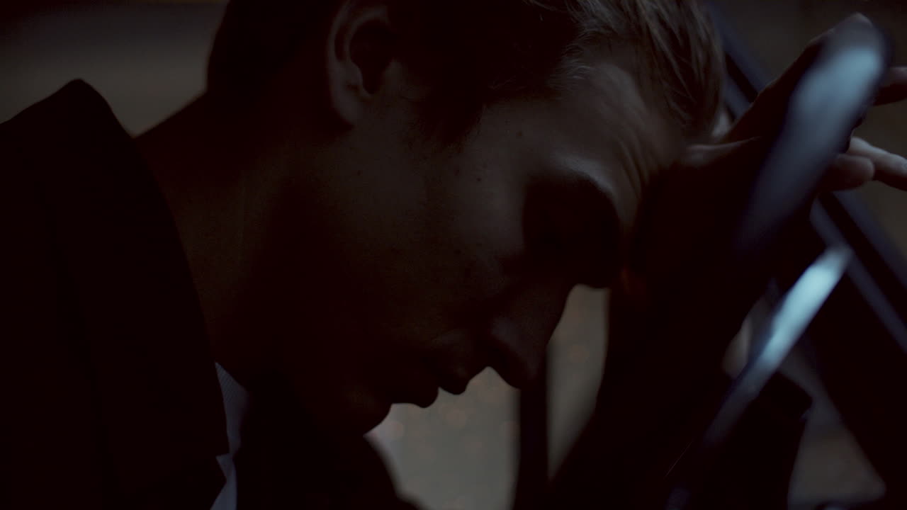 Young Man Sitting in Car, Looking through Windshield at Night