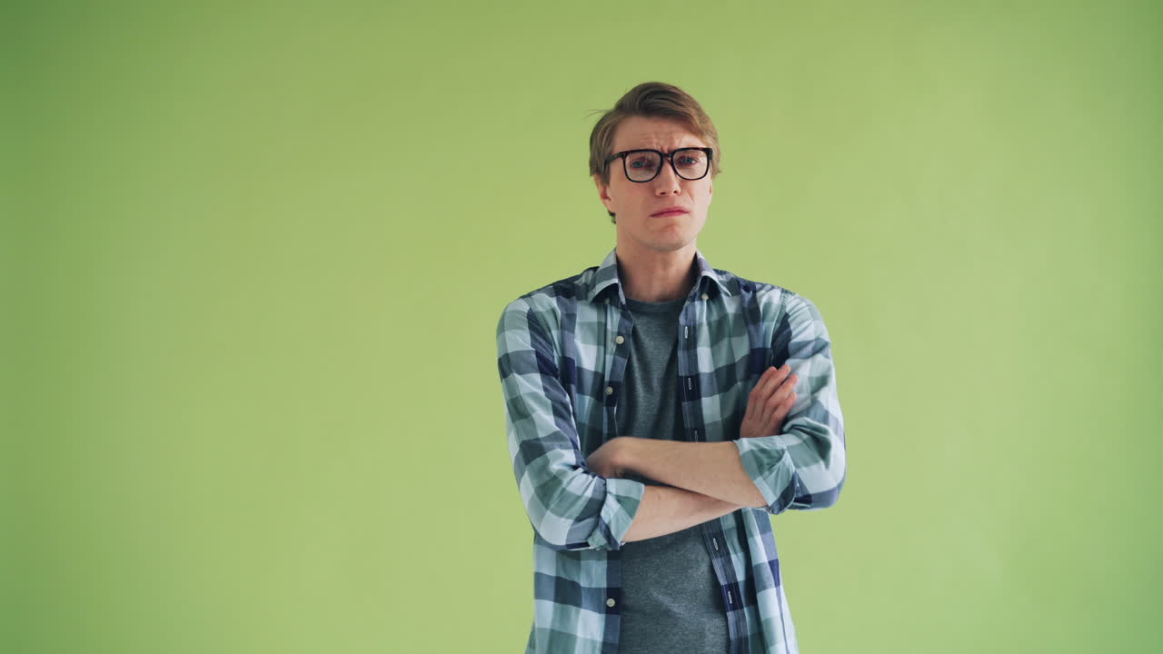 Man with arms crossed, looking bored