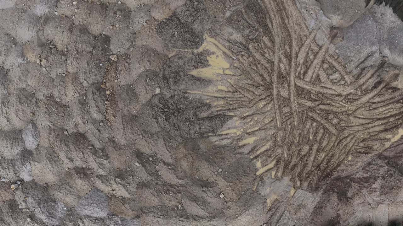 Erdhaufen und Bagger-Spuren auf Baustelle