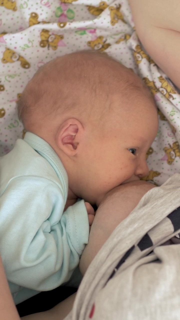 Mum sleeping when nursing newborn baby