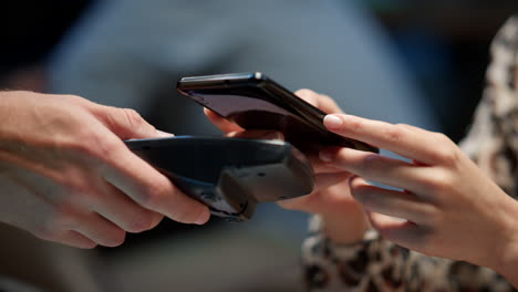 lady hands making contactless payment with smartphone in cafe