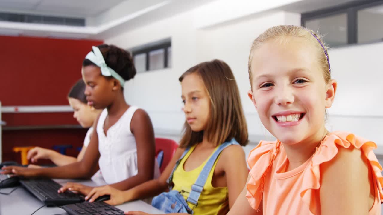 Schoolgirls using computer in classroom